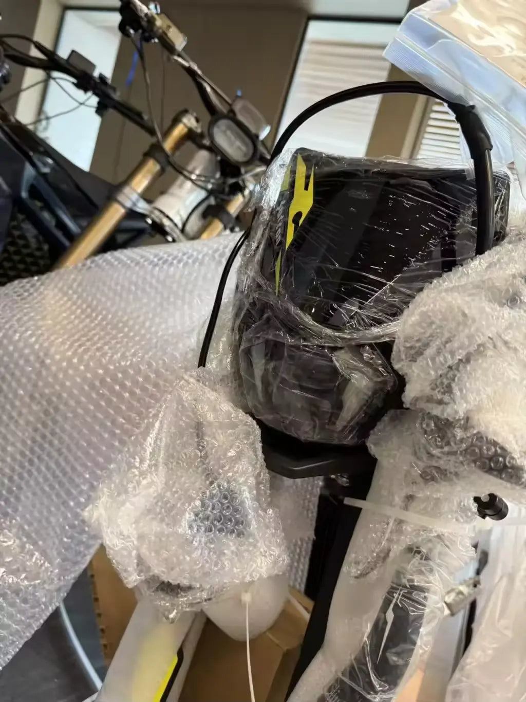 2026 Sur-Ron Light Bee X 3C factory street-legal LED headlight assembly in protective bubble wrap before dispatch.