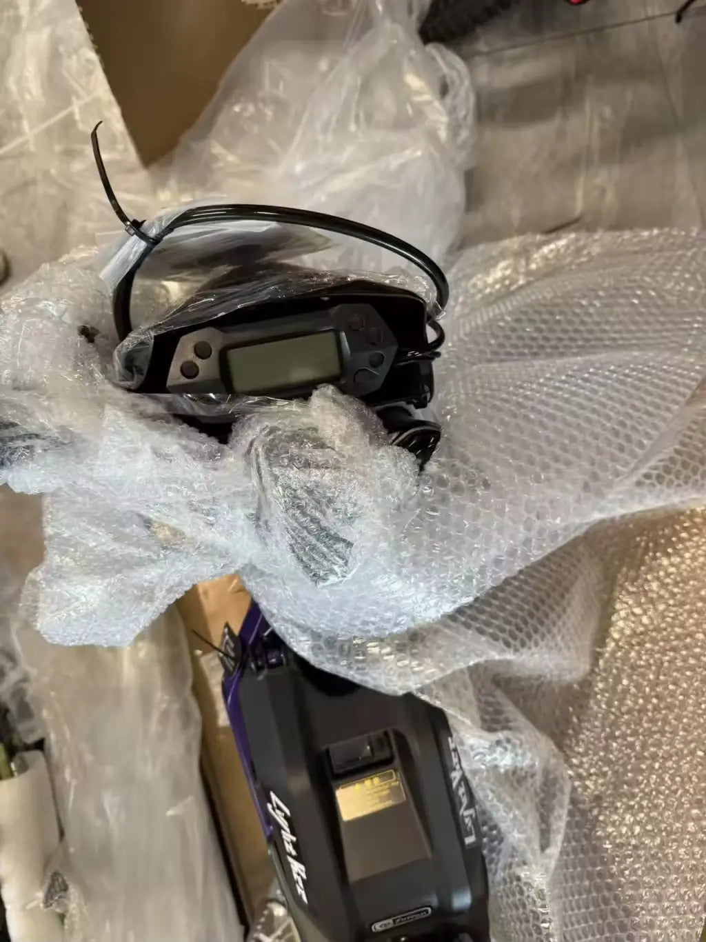 2026 Sur-Ron Light Bee X 3C factory digital speedometer dashboard display and battery cover in protective wrapping.