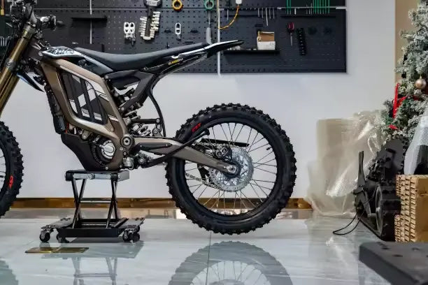 2026 Sur-Ron Light Bee LBX2 rear frame assembly, swingarm, chain drive, and rear knobby off-road tire.