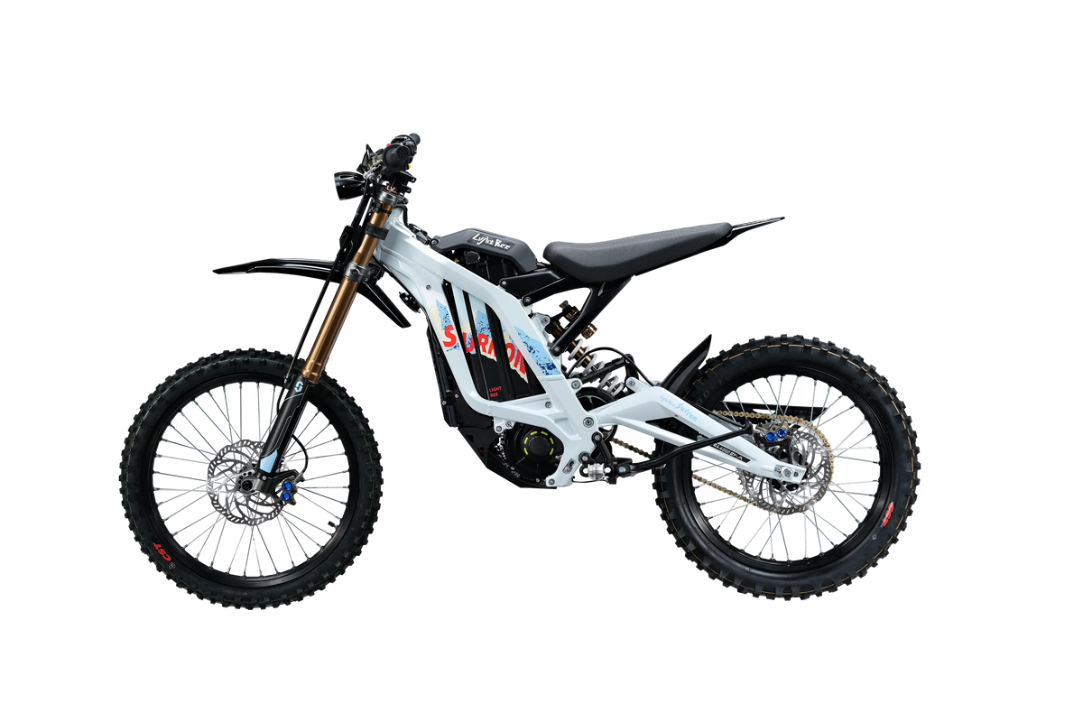 Side profile of white and silver 2026 Sur-Ron Light Bee X (72V 10kW) electric dirt bike highlighting mid-drive PMSM motor, lightweight aluminum frame, and rear chain drive.